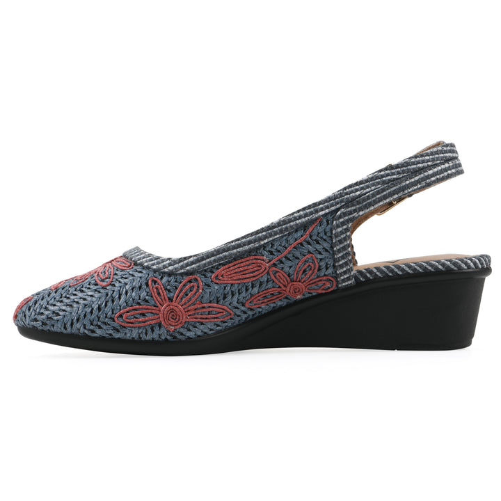 Side view of a woven, blue, raffia slingback with muted red floral detailing and an adjustable heel strap