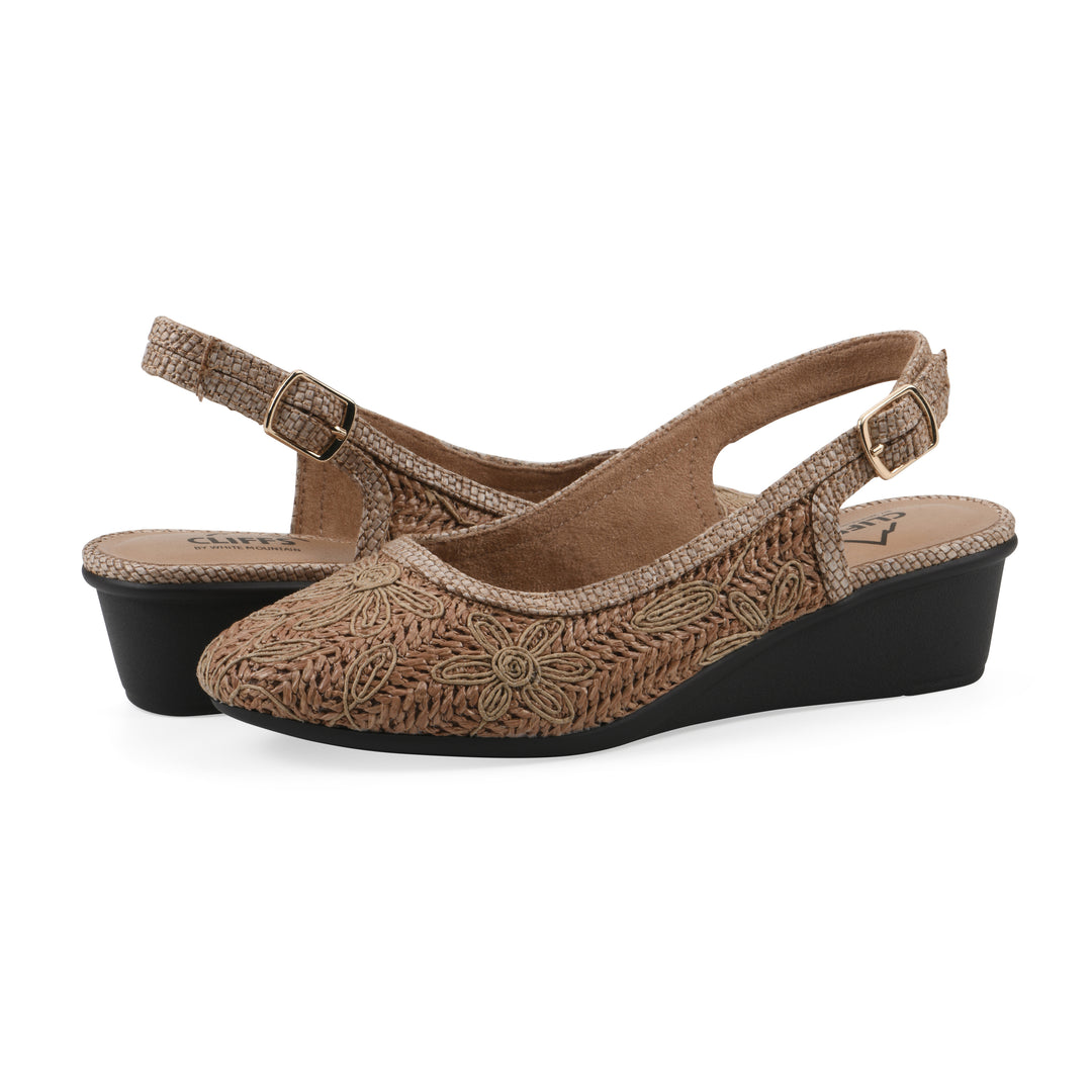 Angle view of a pair of woven, cognac, raffia slingbacks with neutral floral detailing and an adjustable heel strap