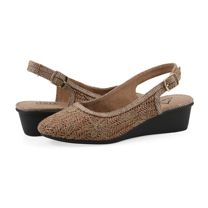 Angle view of a pair of woven, cognac, raffia slingbacks with neutral floral detailing and an adjustable heel strap