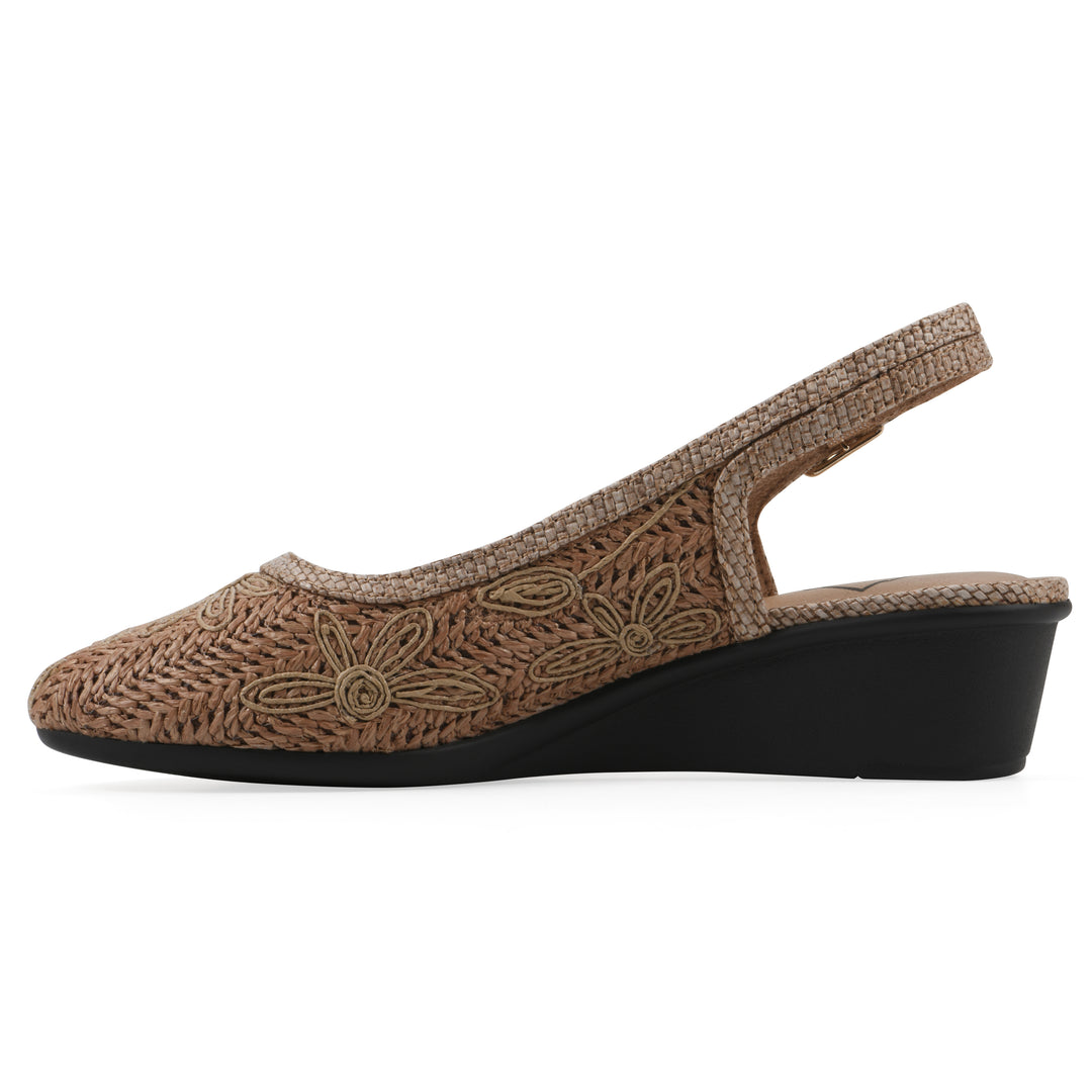 Side view of a woven, cognac, raffia slingback with neutral floral detailing and an adjustable heel strap