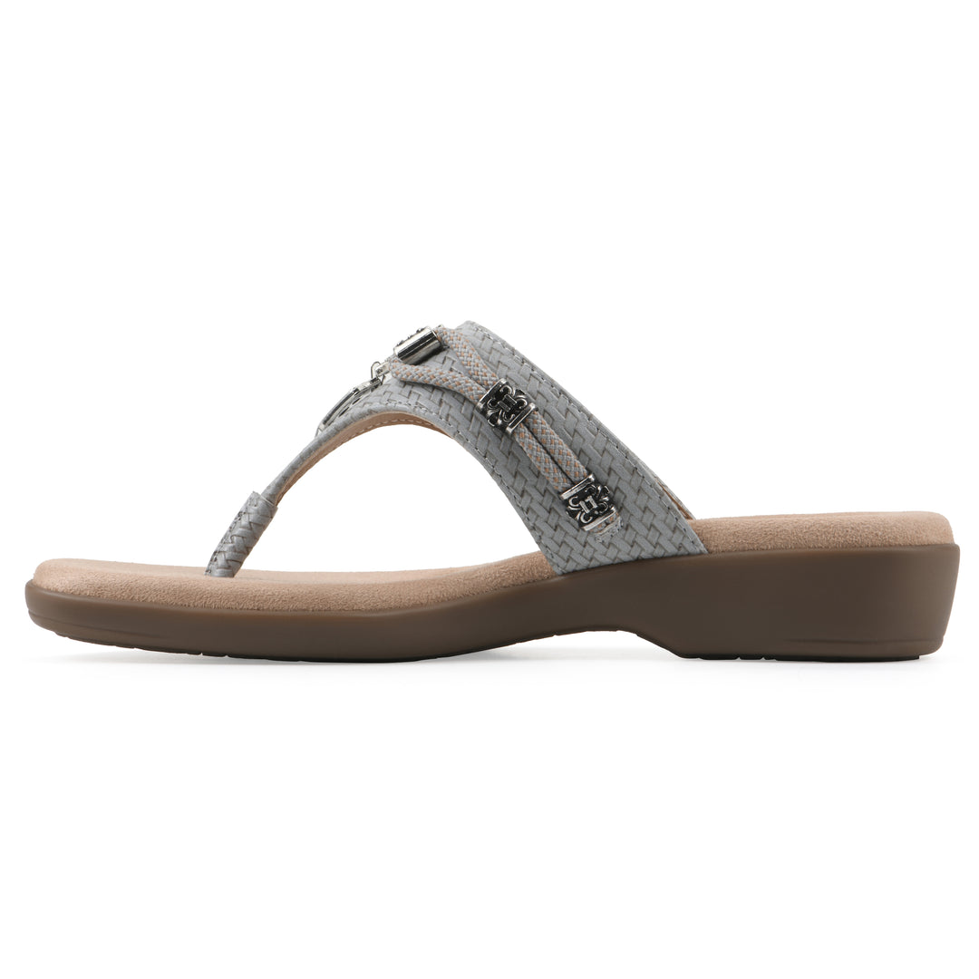 Side view of a slate thong sandal with silver bead embellishments and a tan sole