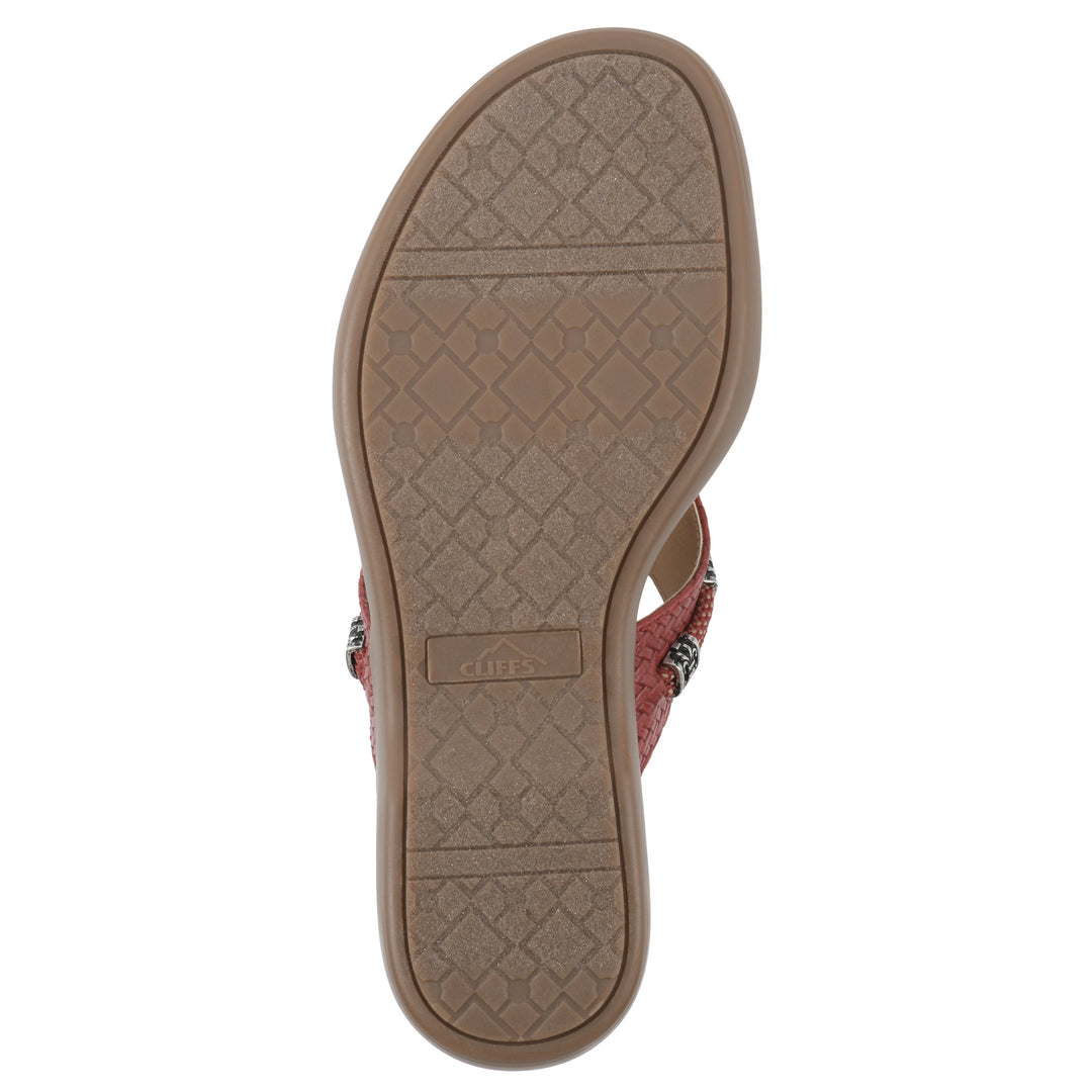 Sole view of a brick red thong sandal with silver bead embellishments and a tan sole