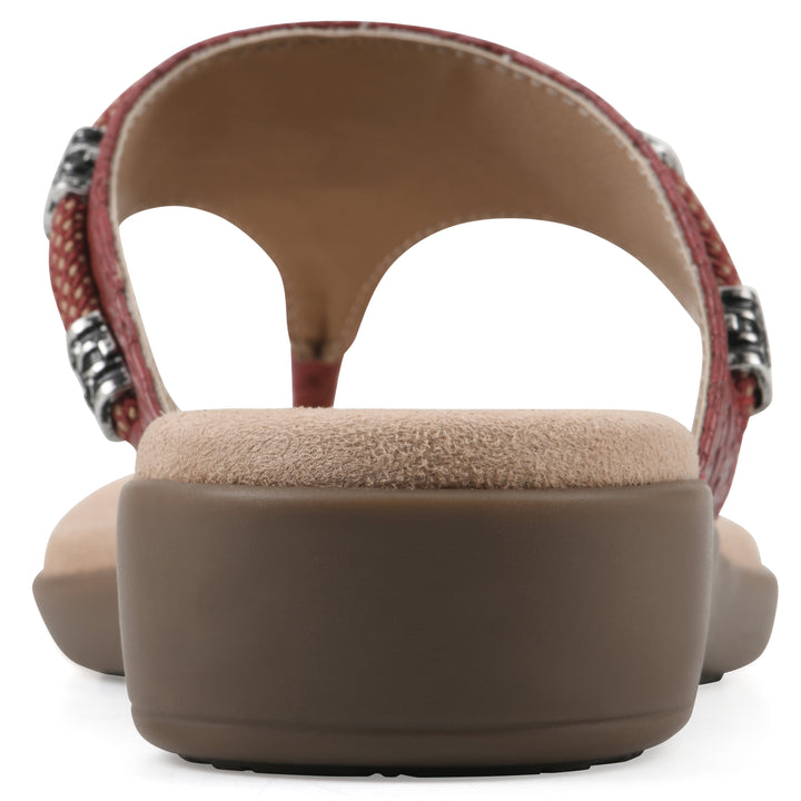 Rear view of a brick red thong sandal with silver bead embellishments and a tan sole