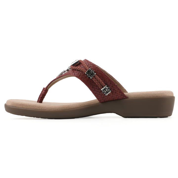 Side view of a brick red thong sandal with silver bead embellishments and a tan sole