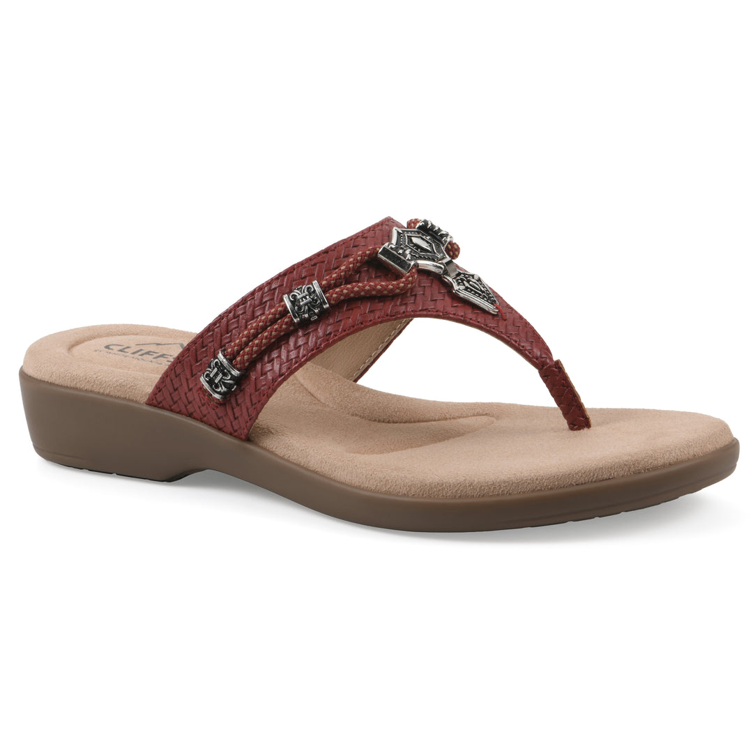 Angle view of a brick red thong sandal with silver bead embellishments and a tan sole