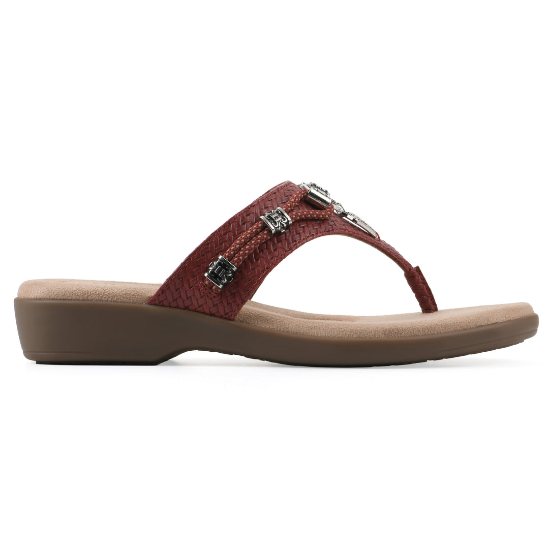 Side view of a brick red thong sandal with silver bead embellishments and a tan sole