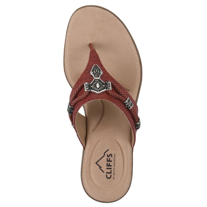 Top view of a brick red thong sandal with silver bead embellishments and a tan sole