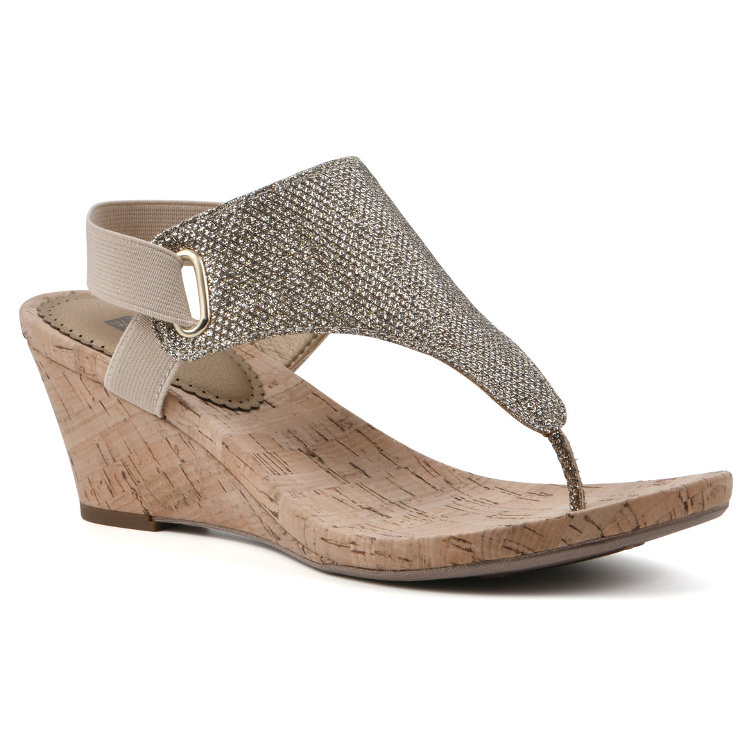 Angle view of a light gold fabric thong wedge sandal with cork heel, and elastic ankle strap