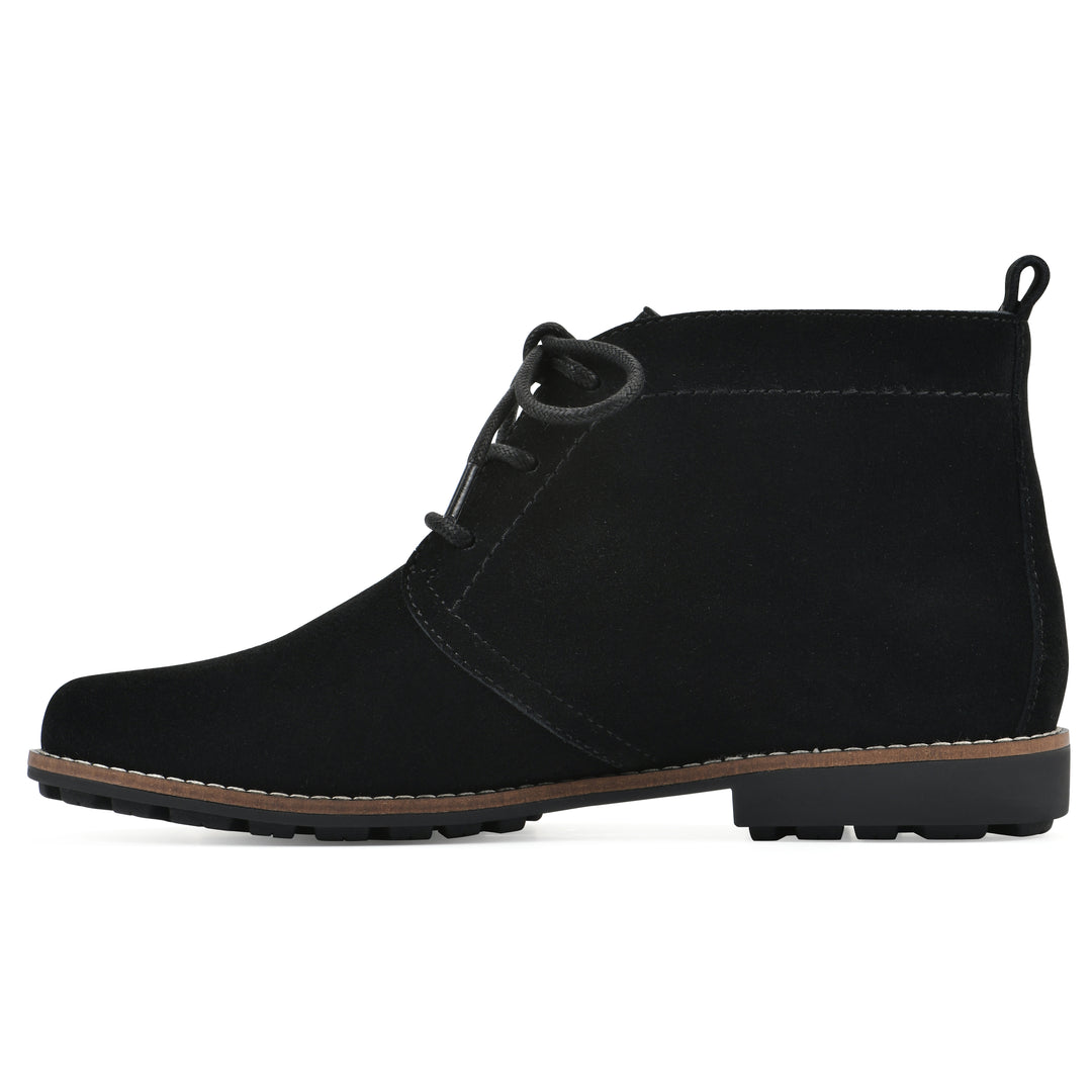 Side view of a black suede bootie with lace-up closure and a low black heel 