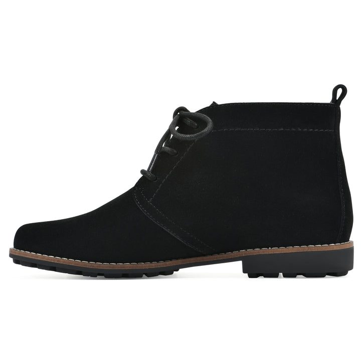 Side view of a black suede bootie with lace-up closure and a low black heel 