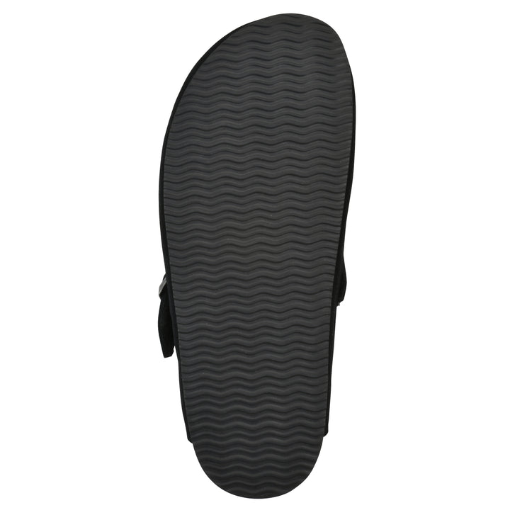 Sole view of a black suede clog with black faux shearling lining, a metal buckle on an adjustable strap, and a brown sole with black patterned bottom