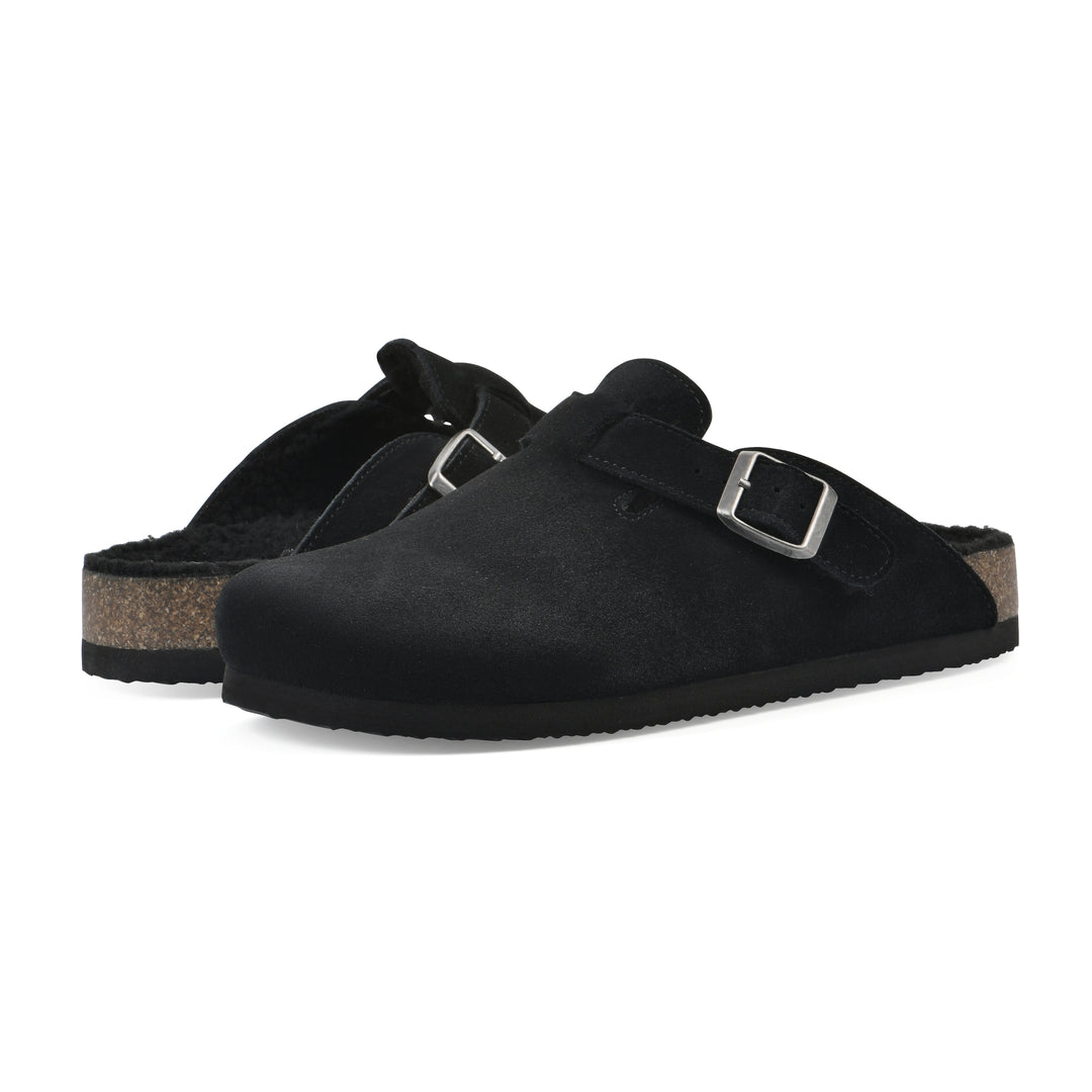 Angle view of a pair of black suede clogs with black faux shearling lining, a metal buckle on an adjustable strap, and a brown sole with black bottom