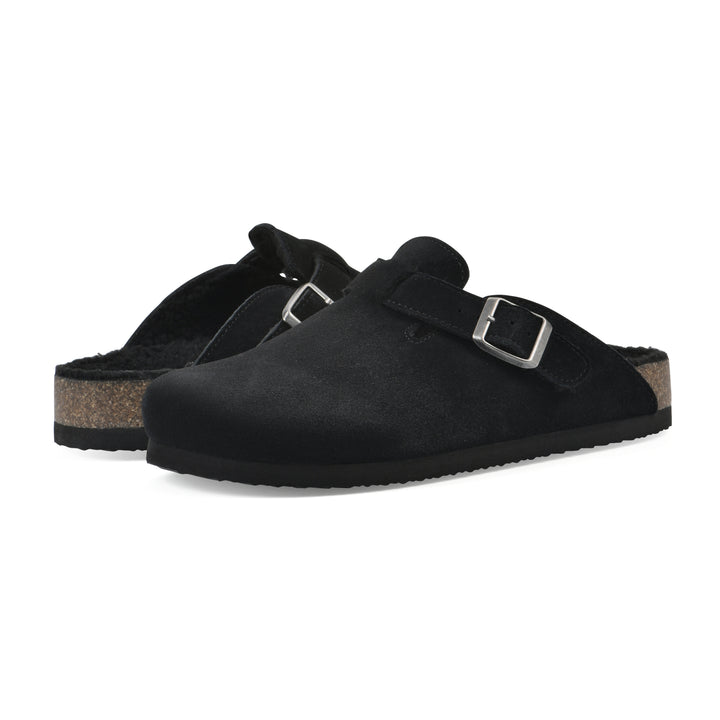 Angle view of a pair of black suede clogs with black faux shearling lining, a metal buckle on an adjustable strap, and a brown sole with black bottom