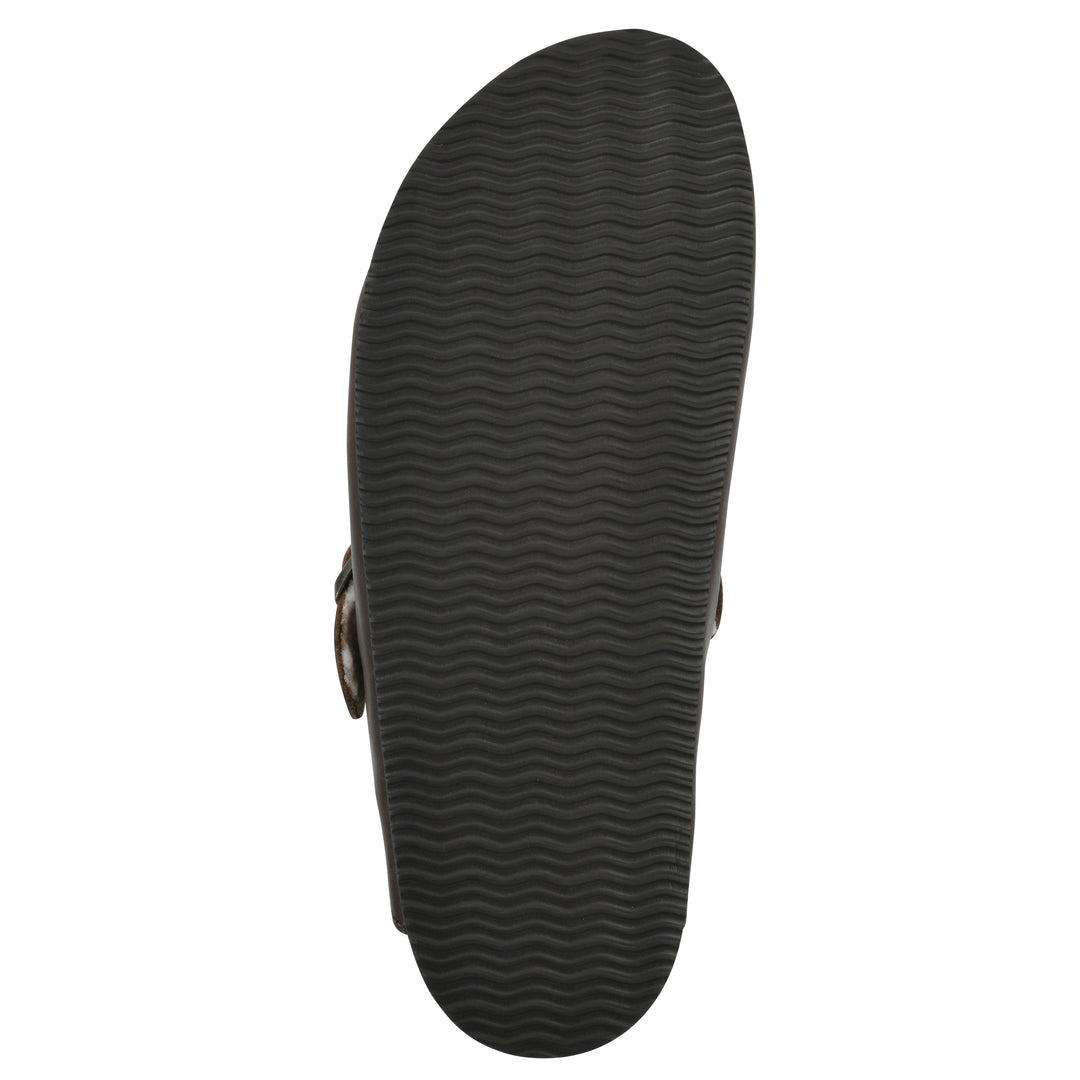 Sole view of a brown leather clog with white faux shearling lining, a metal buckle on an adjustable strap, and a brown sole with black patterned bottom