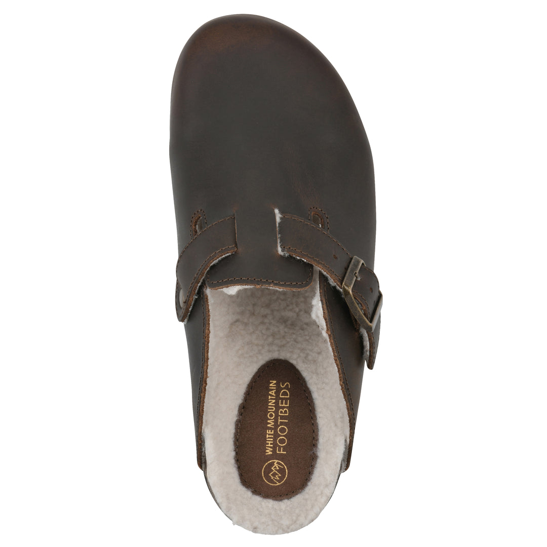 Top view of a brown leather clog with white faux shearling lining, a metal buckle on an adjustable strap, and a brown sole with black bottom