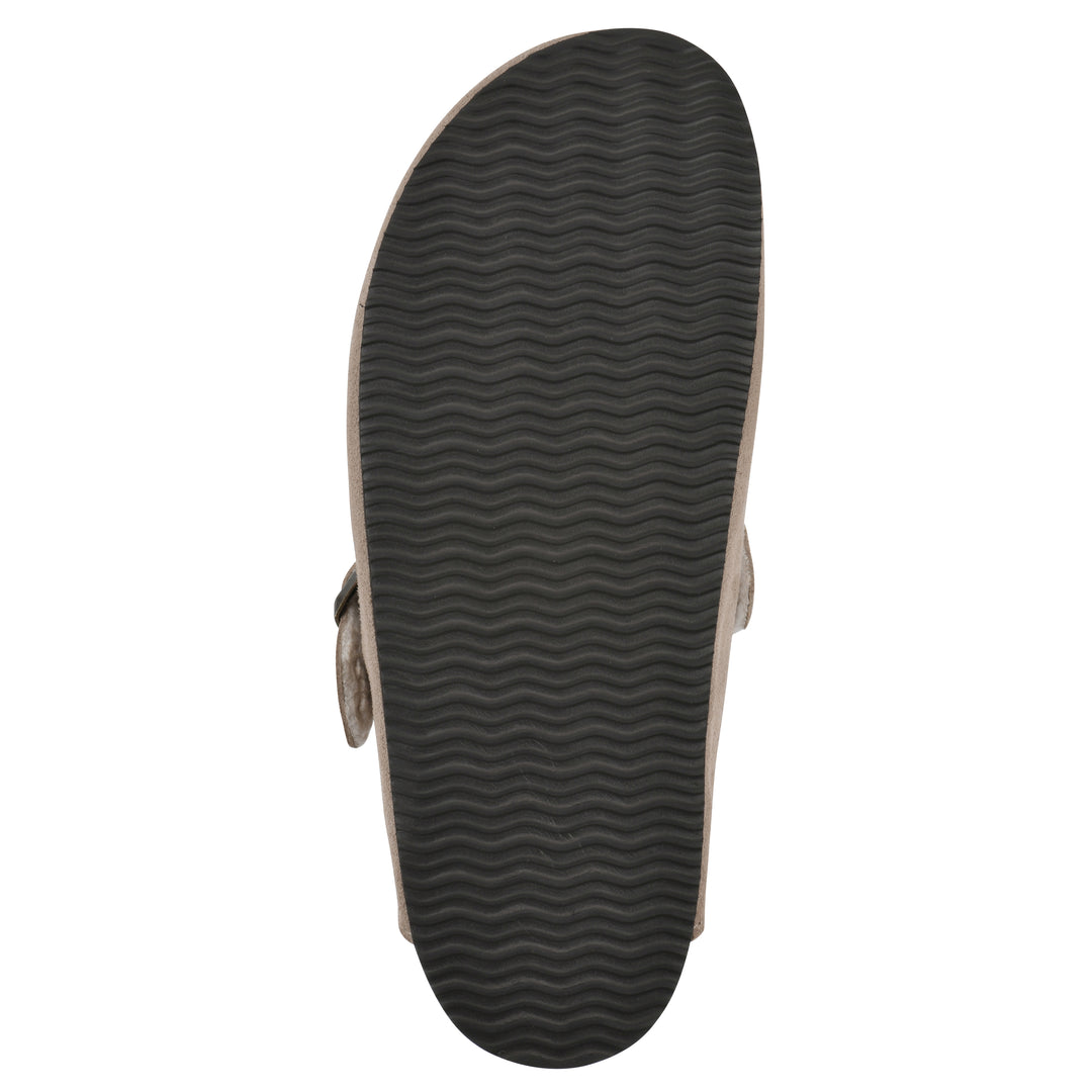 Sole view of a taupe suede clog with white faux shearling lining, a metal buckle on an adjustable strap, and a brown sole with black patterned bottom