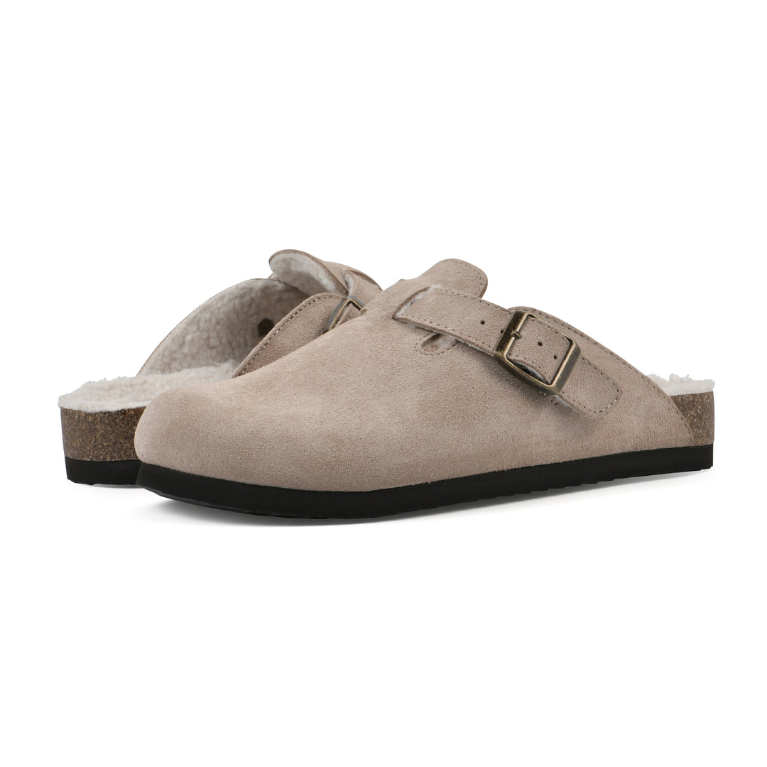 Angle view of a pair of taupe suede clogs with white faux shearling lining, a metal buckle on an adjustable strap, and a brown sole with black bottom