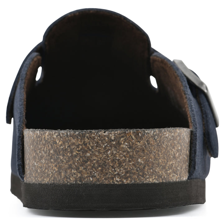 Rear view of a navy suede clog with metal buckle on an adjustable strap, and a brown sole with black bottom