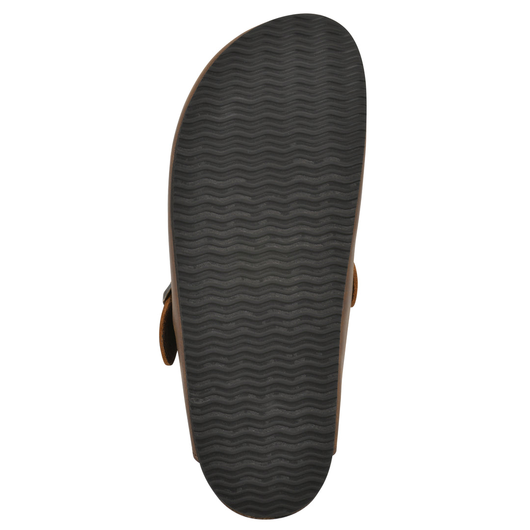 Sole view of a whiskey leather clog with metal buckle on an adjustable strap, and a brown sole with black patterned bottom