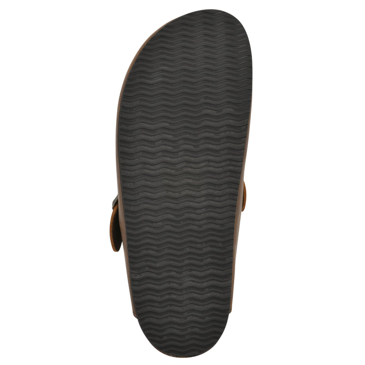Sole view of a whiskey leather clog with metal buckle on an adjustable strap, and a brown sole with black patterned bottom