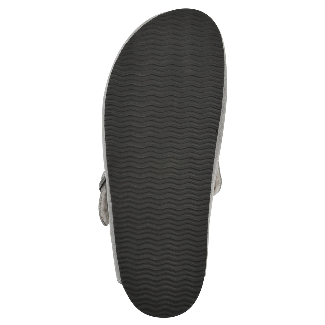 Sole view of a light grey suede clog with white faux shearling lining, a metal buckle on an adjustable strap, and a brown sole with black patterned bottom