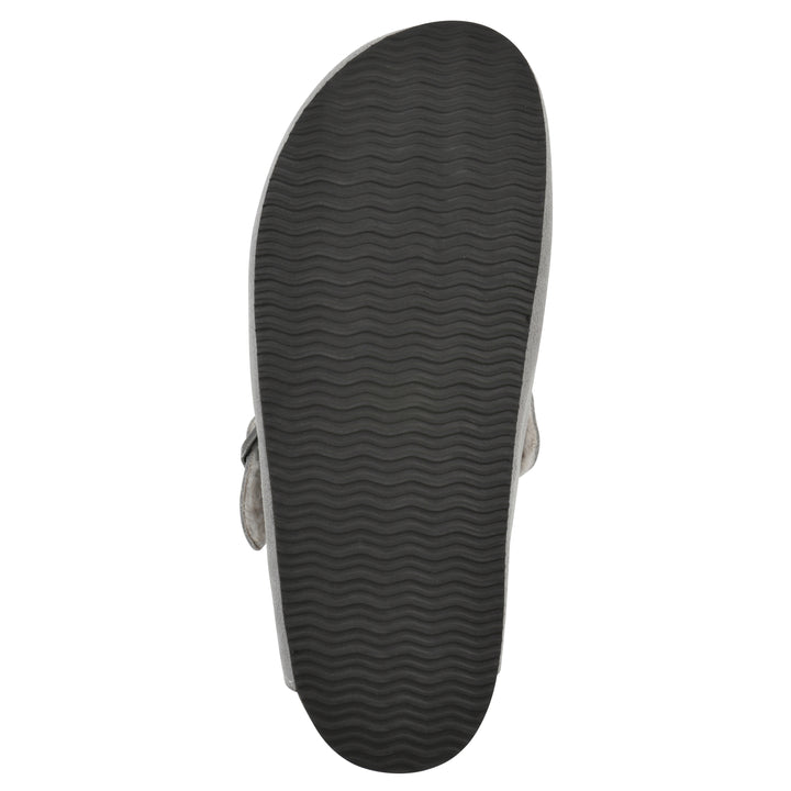 Sole view of a light grey suede clog with white faux shearling lining, a metal buckle on an adjustable strap, and a brown sole with black patterned bottom