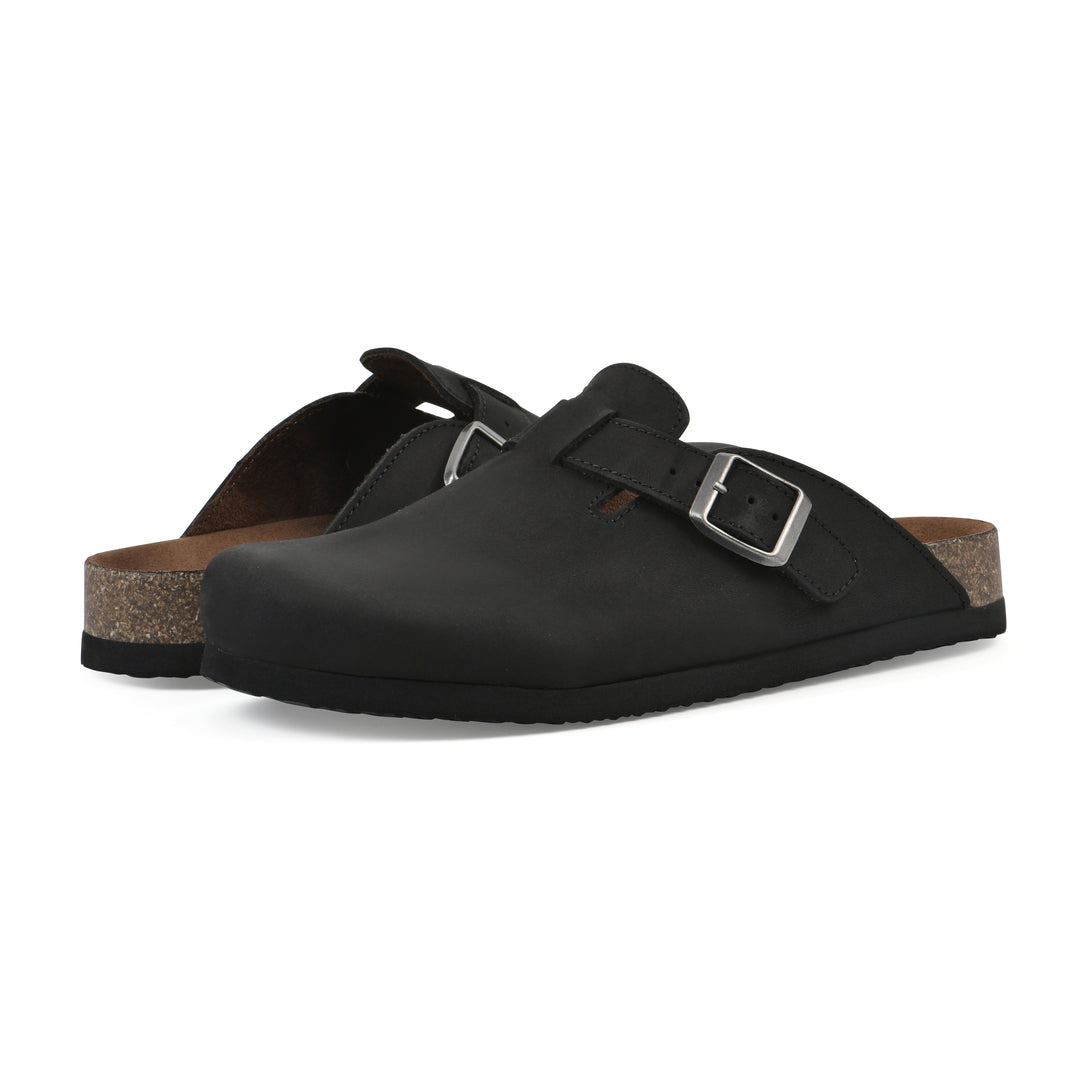 Angle view of a pair of black leather clog with metal buckle on an adjustable strap, and a brown sole with black bottom