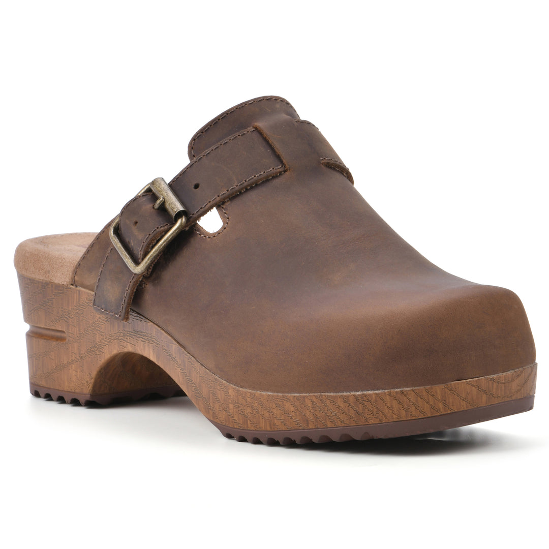 Angle view of a backless brown leather clog with adjustable buckle and wood style heel