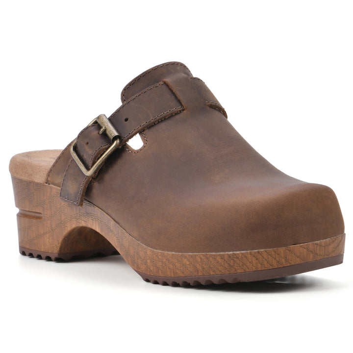 Angle view of a backless brown leather clog with adjustable buckle and wood style heel