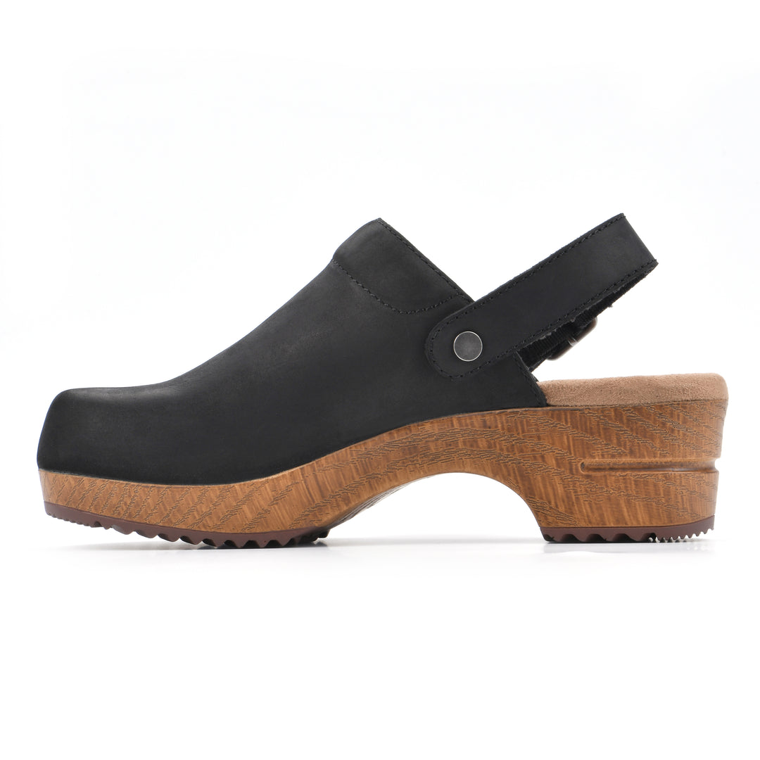 Side view of a backless black leather clog with adjustable back strap and wood style heel