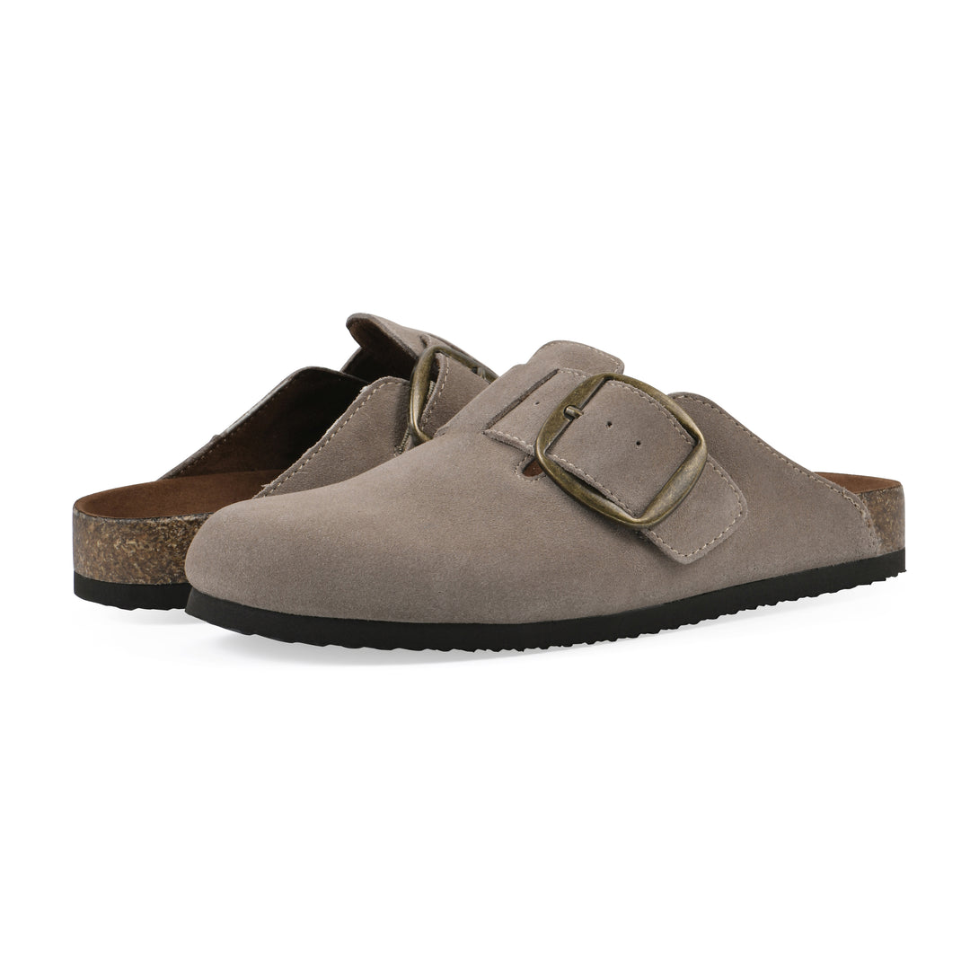 Angle view of a pair of taupe suede backless clogs with large adjustable buckle and a black sole