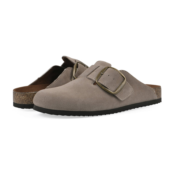Angle view of a pair of taupe suede backless clogs with large adjustable buckle and a black sole