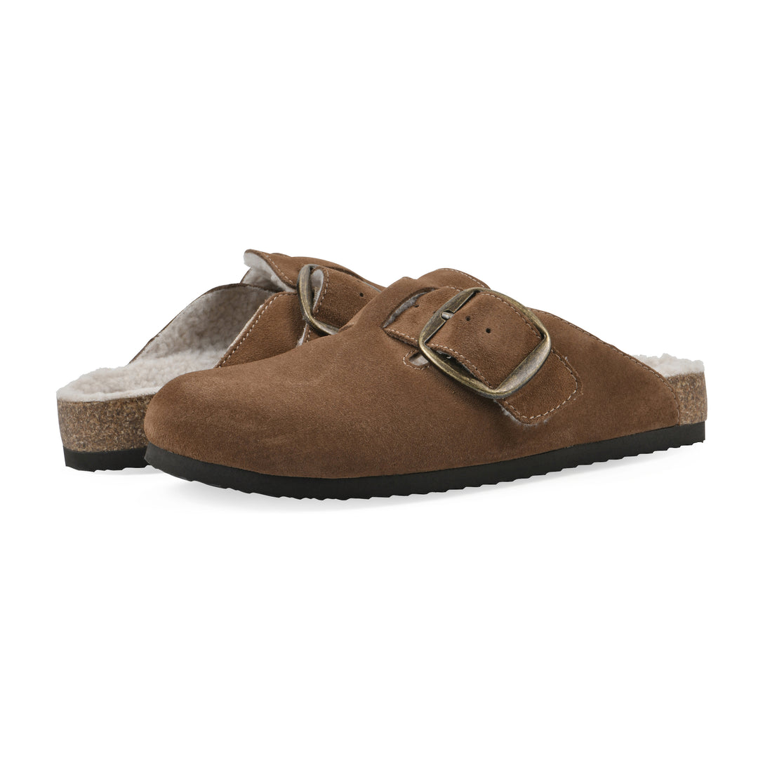Angle view of a pair of chestnut suede backless clogs with cream, faux fur lining, a large adjustable buckle, and a black sole