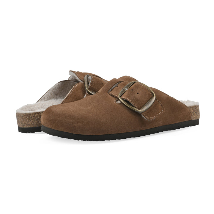 Angle view of a pair of chestnut suede backless clogs with cream, faux fur lining, a large adjustable buckle, and a black sole
