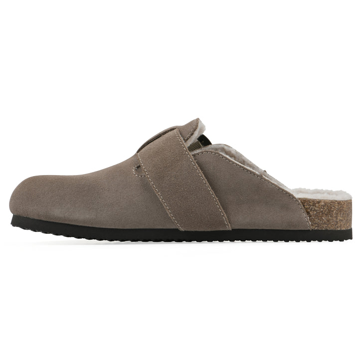 Side view of a taupe suede backless clog with cream, faux fur lining, a large adjustable buckle, and a black sole