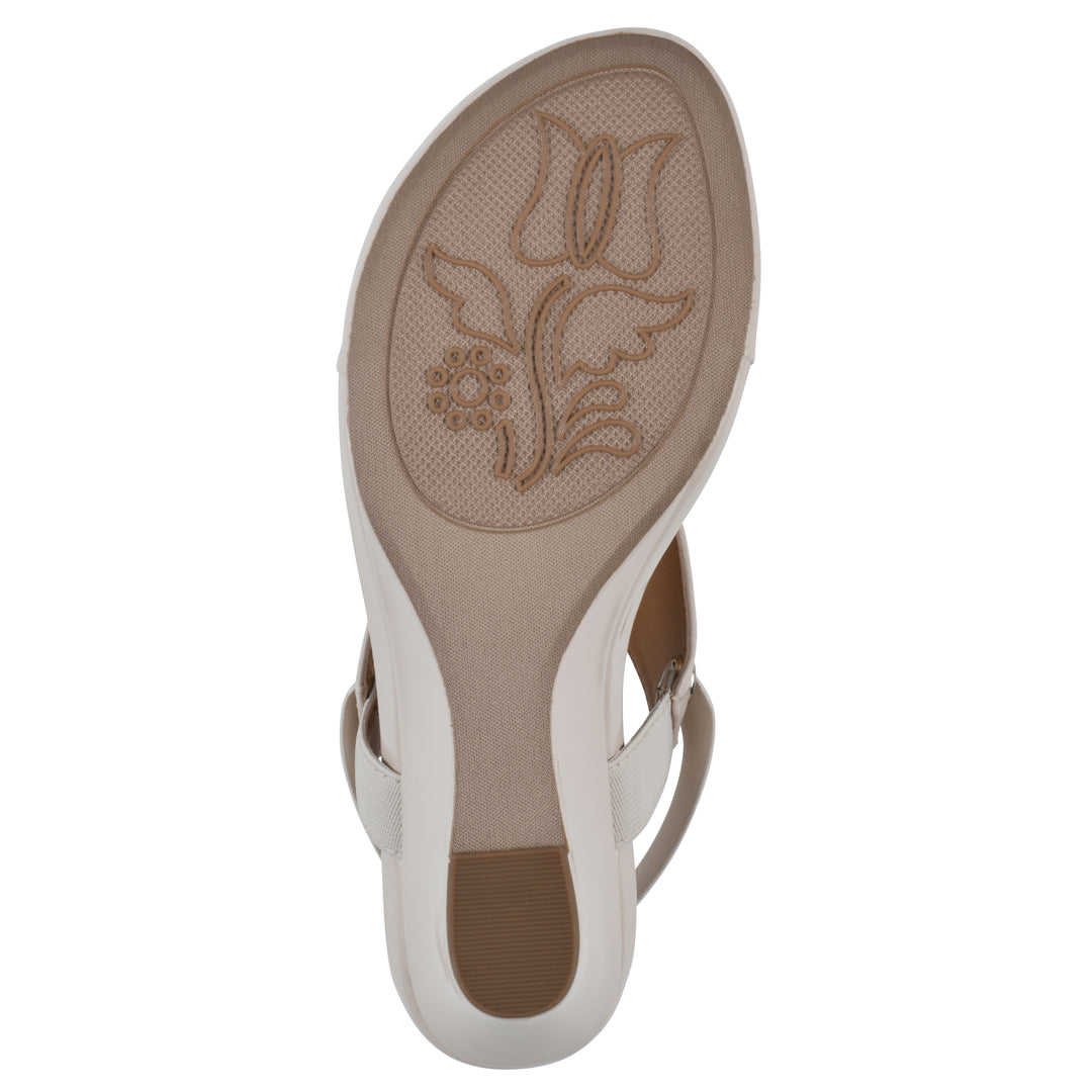 Sole view of an eggshell patent thong wedge sandal with a wrapped heel, elastic ankle strap, and eggshell sole