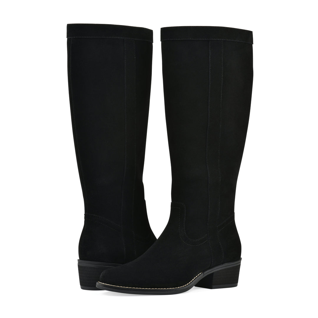 Angle view of a pair of black suede tall boots with a low stacked, black heel, and tapered toe