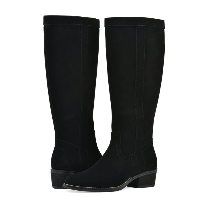 Angle view of a pair of black suede tall boots with a low stacked, black heel, and tapered toe