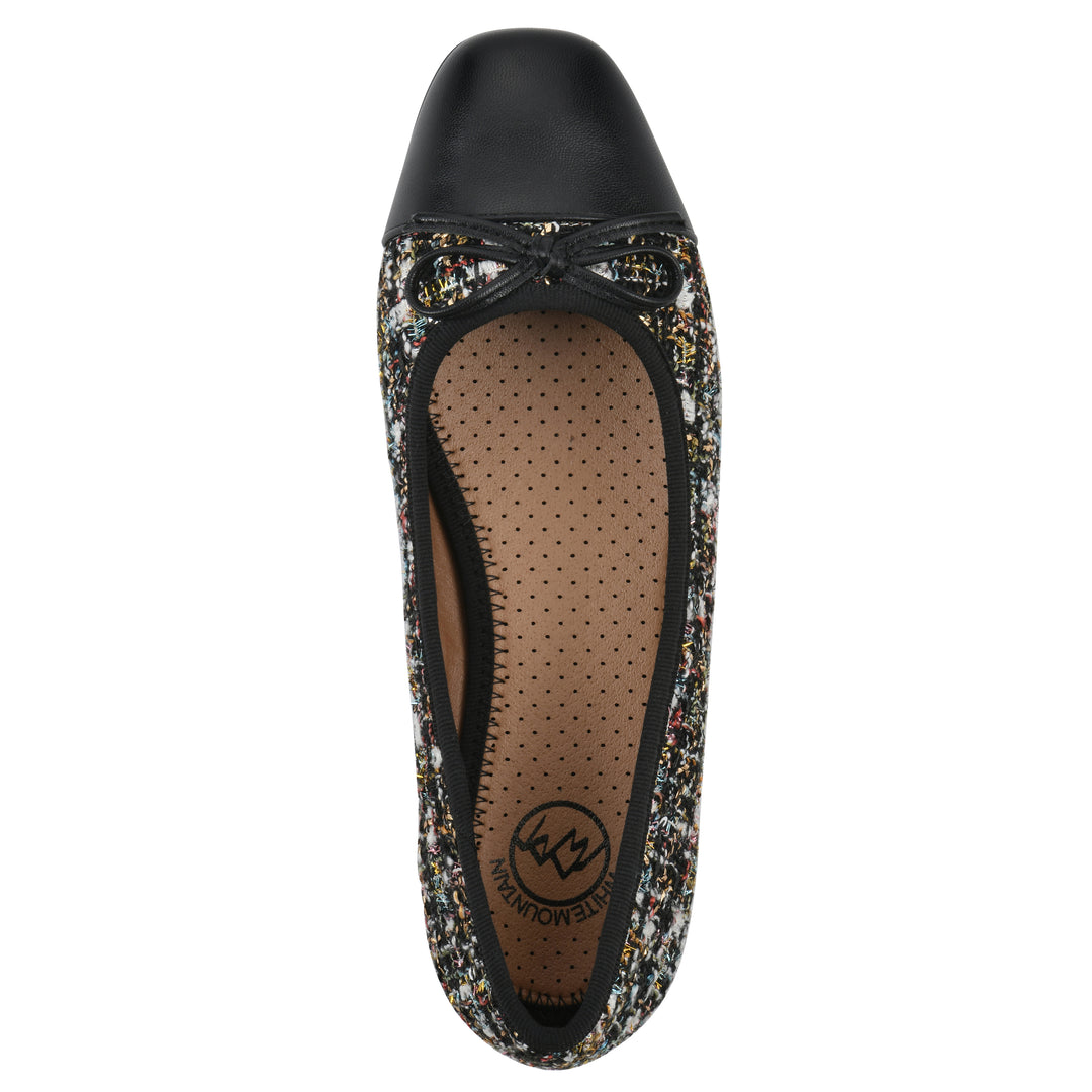 Top view of a black boucle fabric flat with small, centered black bow, a smooth black patent toe cap, and a black sole