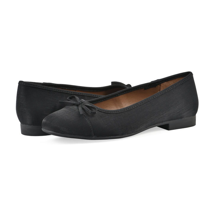 Angle view of a pair of black shimmer fabric flats with small, centered black bow and a black sole