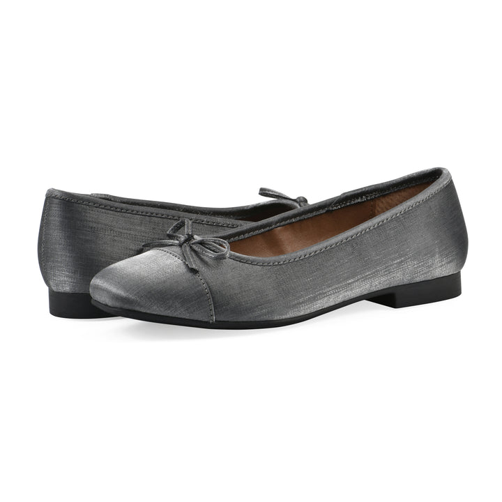 Angle view of a pair of gunmetal shimmer fabric flats with small, centered black bow and a black sole