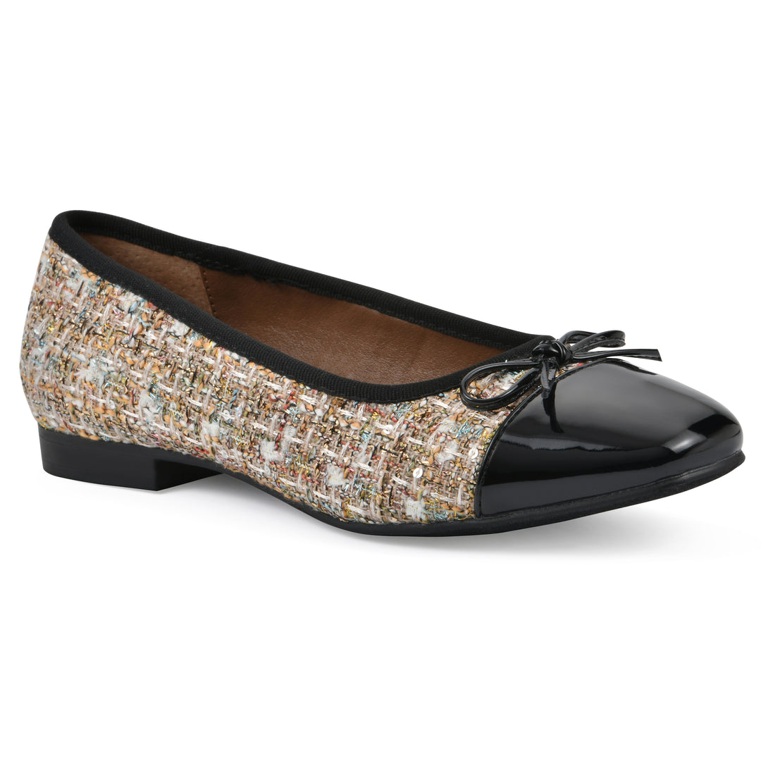 Angle view of a beige boucle fabric flat with small, centered black bow, a smooth black patent toe cap, and a black sole