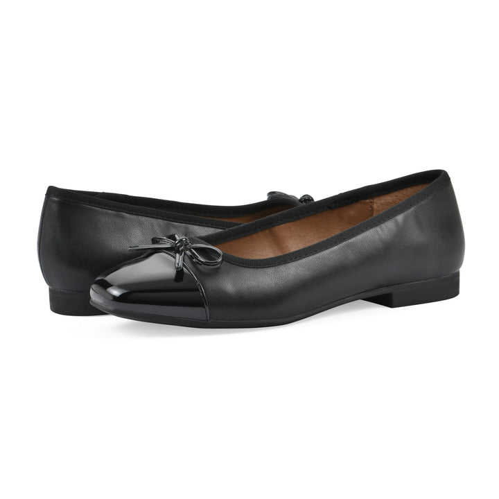 Angle view of a pair of black faux leather flats with small, centered black bow, a smooth black patent toe cap, and a black sole