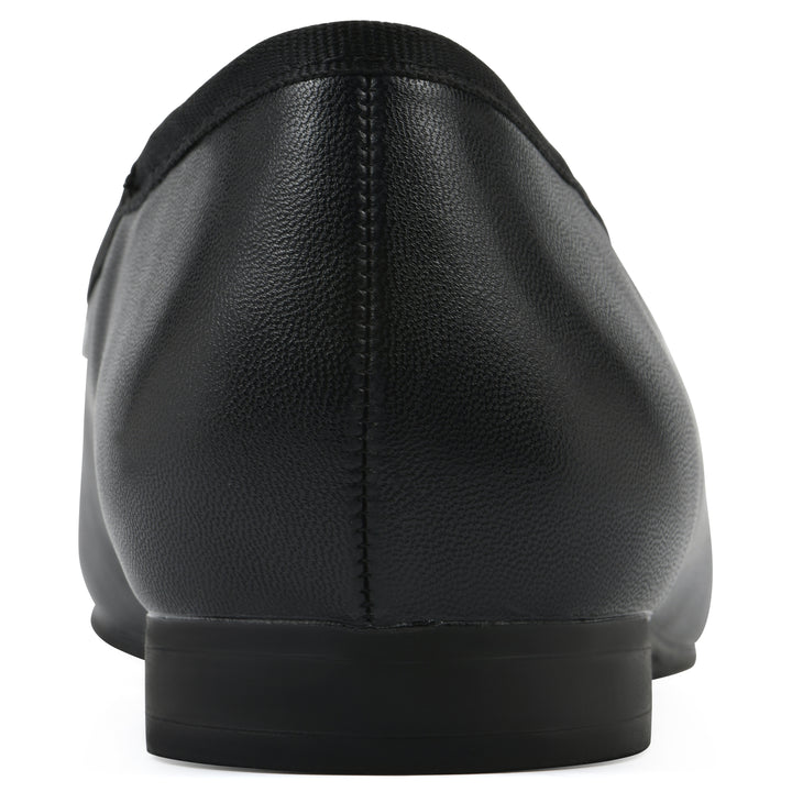 Rear view of a black faux leather flat with small, centered black bow, a smooth black patent toe cap, and a black sole