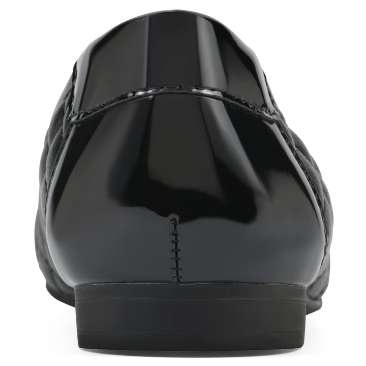 Rear view of a black quilted pattern flat with smooth patent toe cap, small, centered bow and a black sole