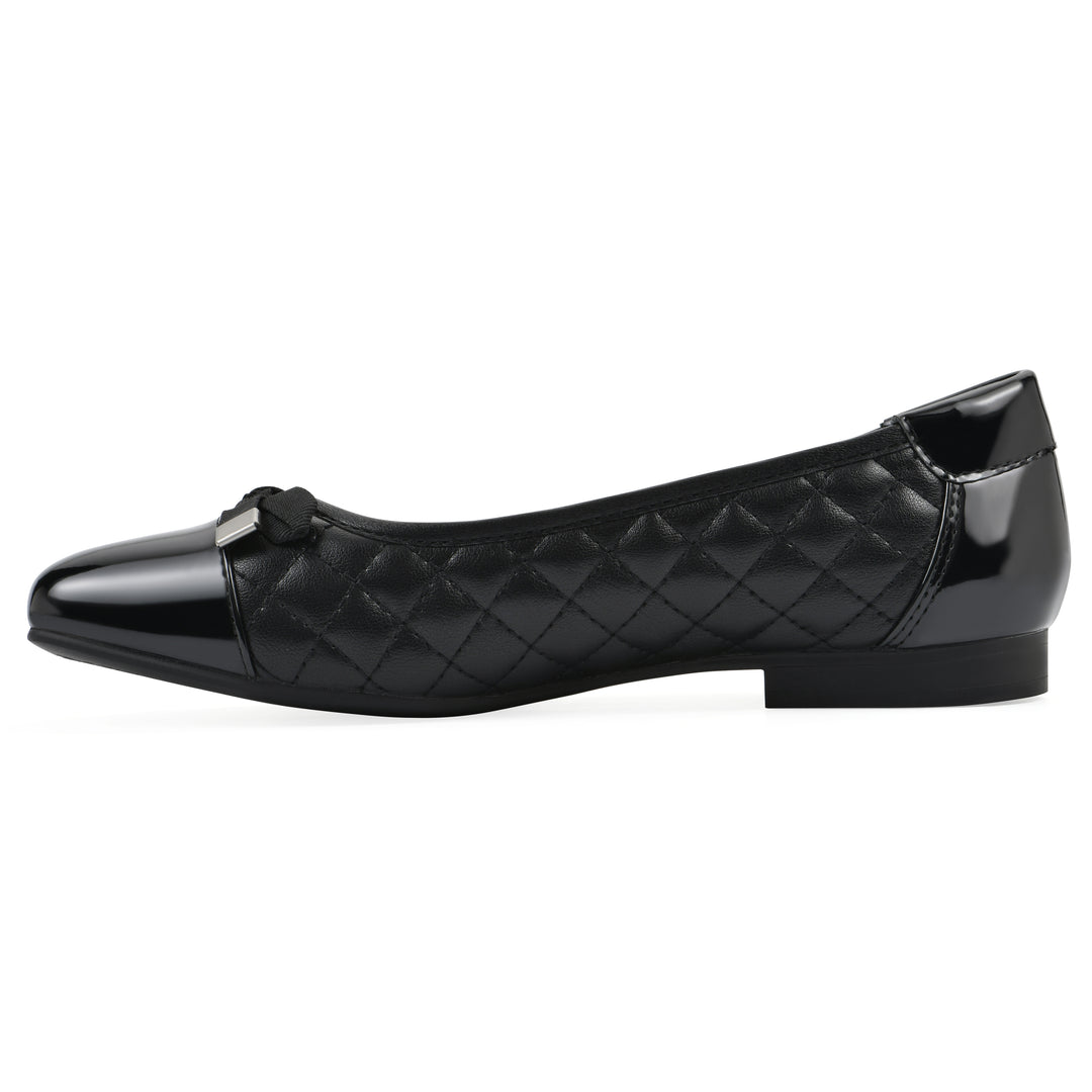 Side view of a black quilted pattern flat with smooth patent toe cap, small, centered bow and a black sole