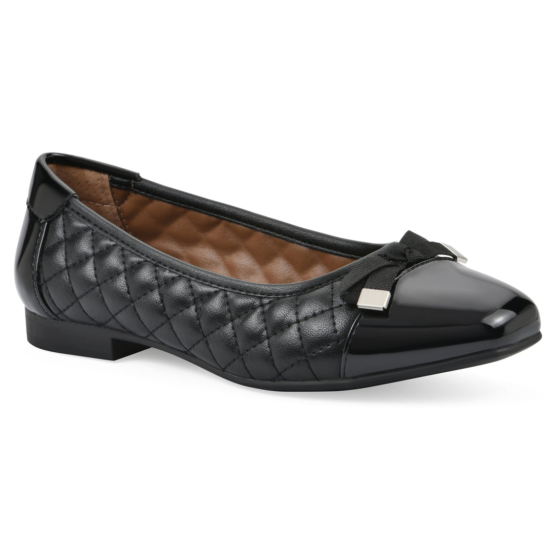 Angle view of a black quilted pattern flat with smooth patent toe cap, small, centered bow and a black sole