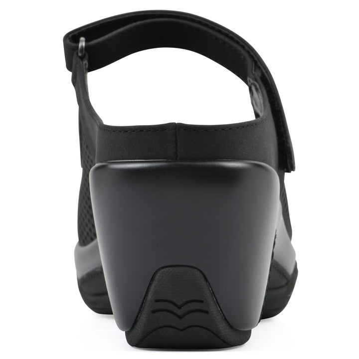 Rear view of a black colored clog with a closed toe and adjustable strap, featuring a perforated diamond design and a low heel.