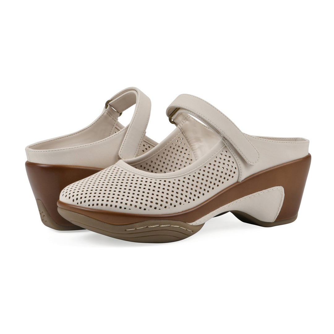 Angel view of a pair of egg shell colored clog with a closed toe and adjustable strap, featuring a perforated diamond design and a low heel.