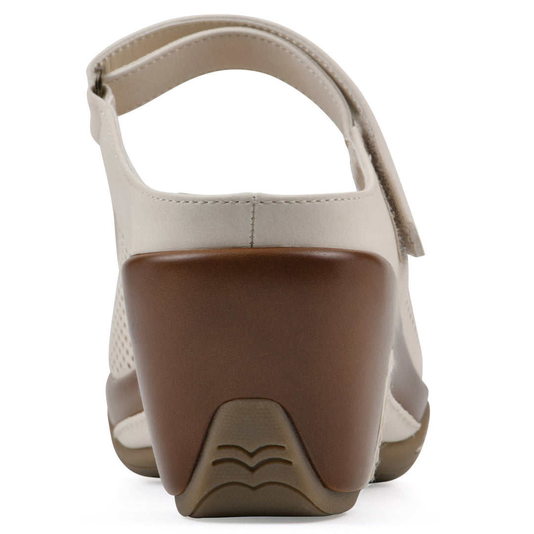 Rear view of a egg shell colored clog with a closed toe and adjustable strap, featuring a perforated diamond design and a low heel.